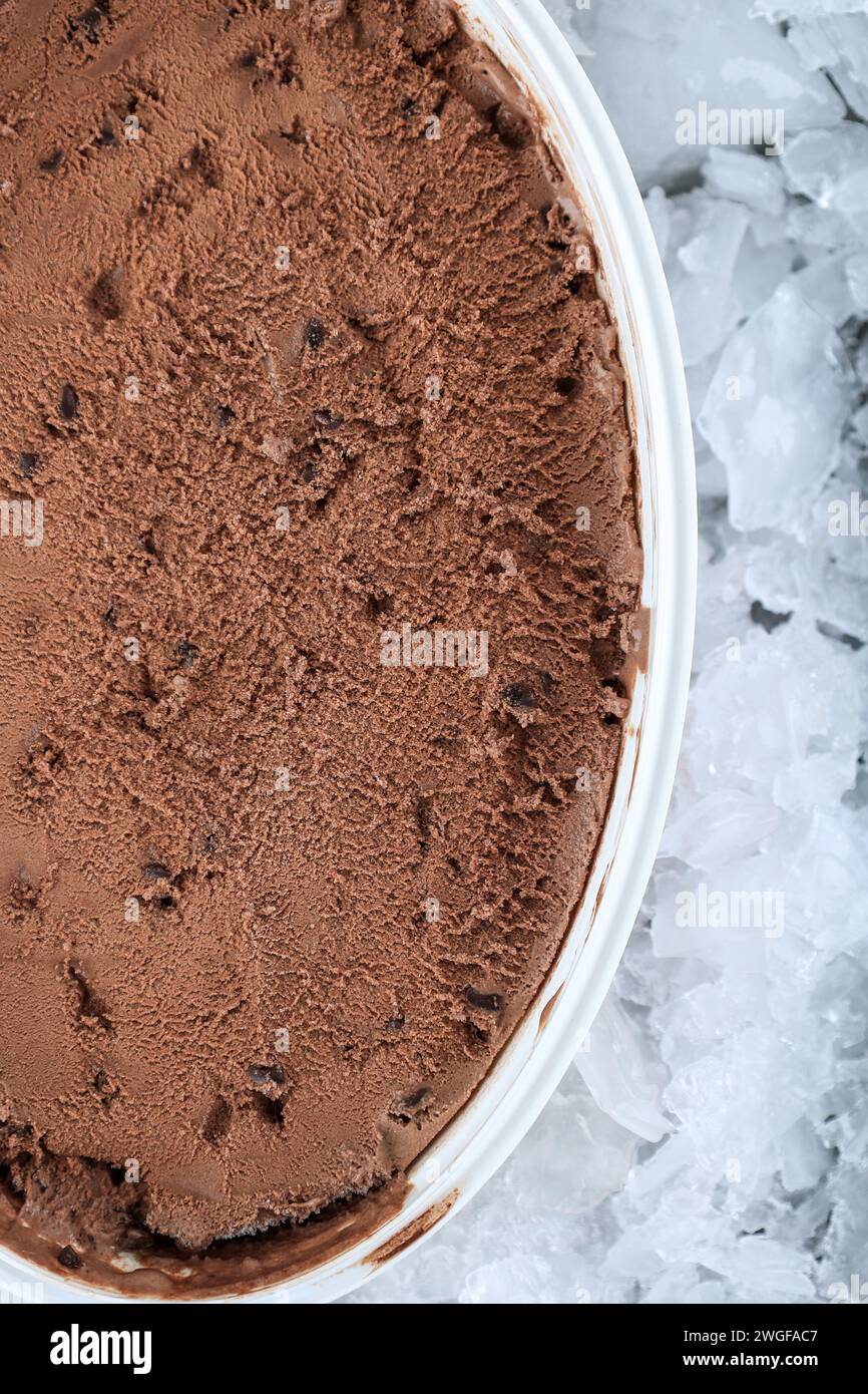 Vista dall'alto della struttura del gelato con deliziosi cioccolatini e cioccolato su un contenitore di plastica, confezione con cubetto di ghiaccio tritato Foto Stock