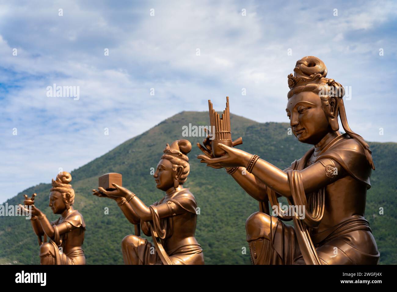 Statua delle divinità indù seduta su un piedistallo con una figura in piedi Foto Stock