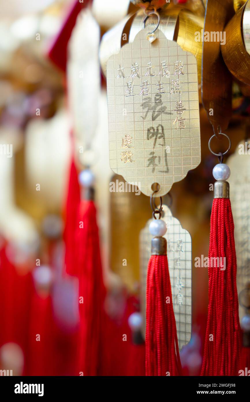 Le etichette di carta cinesi sono appese ai ganci su un albero di Natale splendidamente decorato Foto Stock