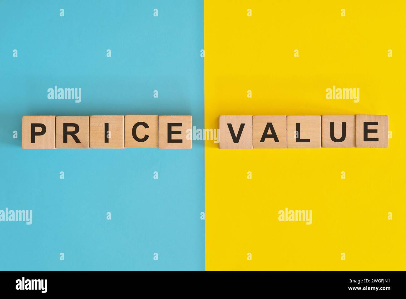 Prezzo rispetto al valore nel business e concetto di consumismo. Tipografia con blocchi di legno su sfondo blu e giallo. Foto Stock