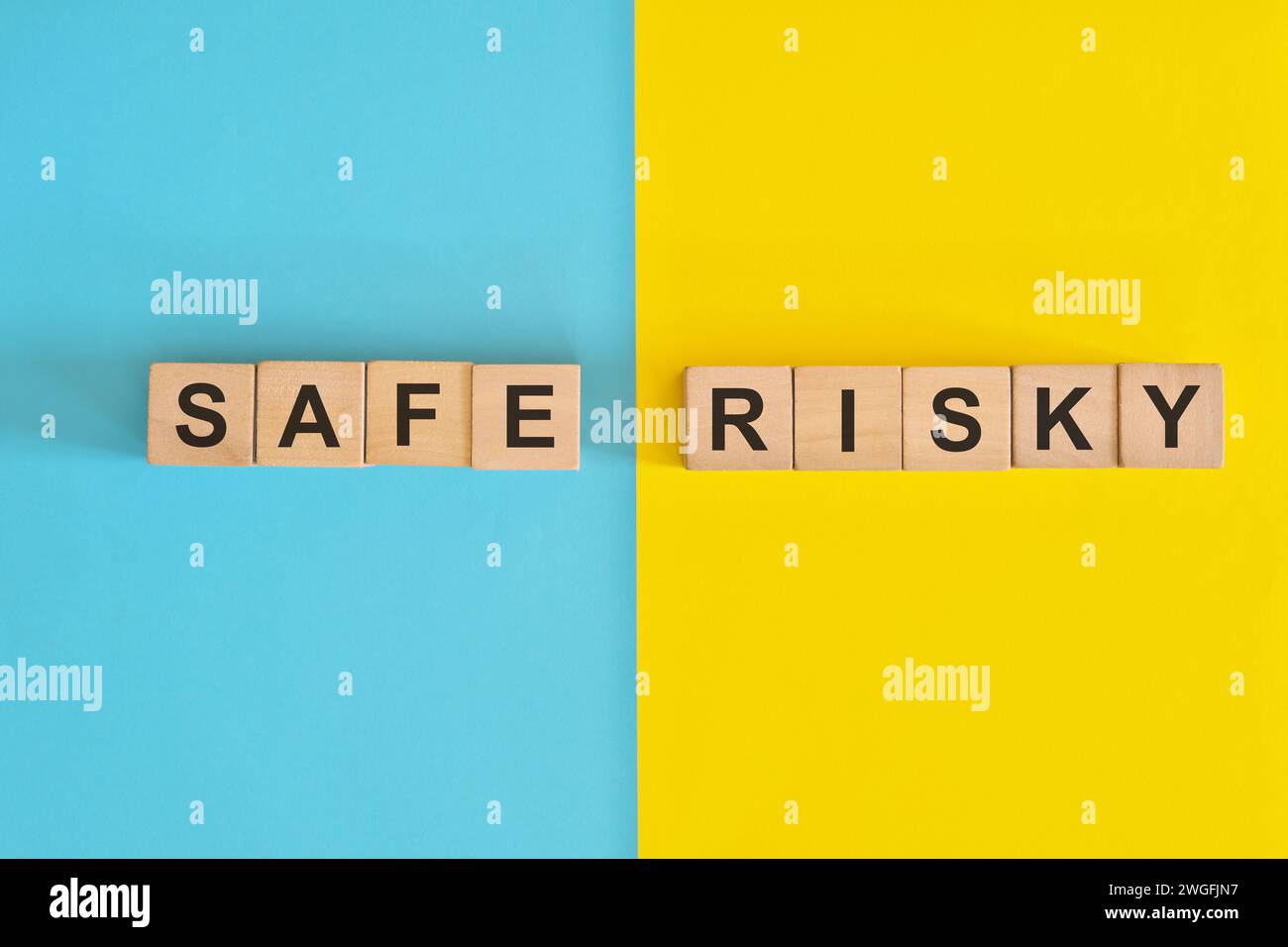 Sicurezza contro rischio in investimenti e concetto aziendale. Tipografia con blocchi di legno su sfondo blu e giallo. Foto Stock