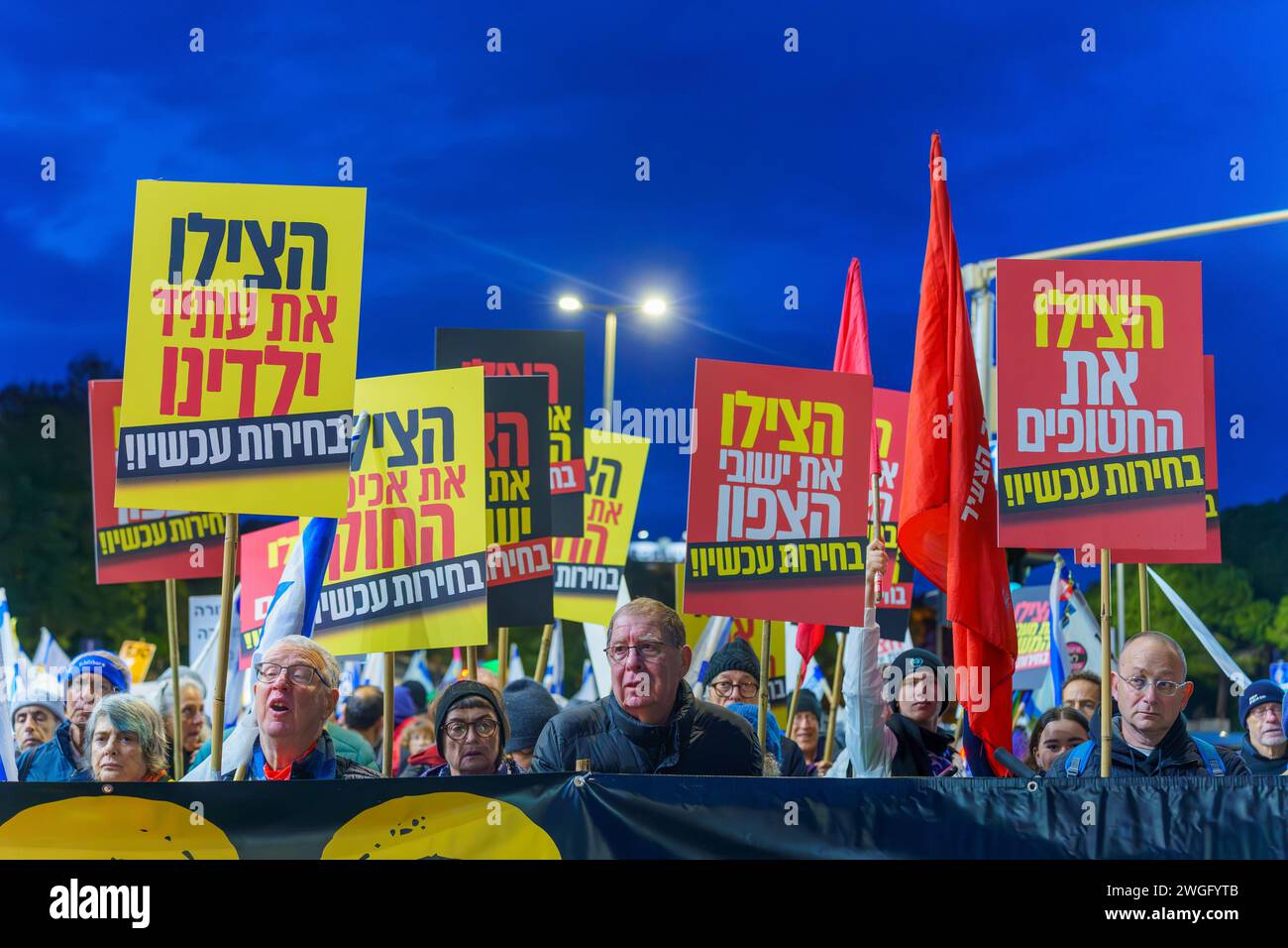 Haifa, Israele - 3 febbraio 2024: La gente marcia con vari segni e bandiere in segno di protesta contro il governo, chiedendo nuove elezioni. Haifa, Isra Foto Stock