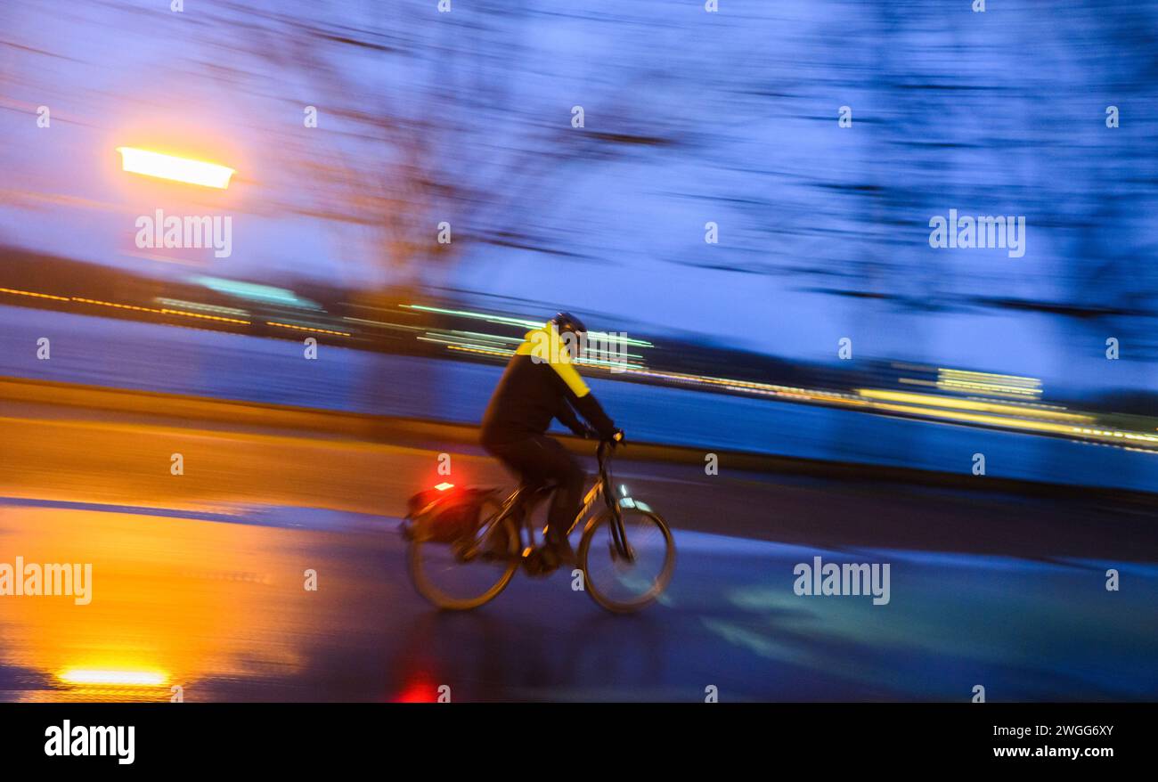 Hannover, Germania. 5 febbraio 2024. Nella tempesta mattutina e nella pioggia, un ciclista corre lungo il Maschsee (girato a bassa velocità dell'otturatore). Credito: Julian Stratenschulte/dpa/Alamy Live News Foto Stock