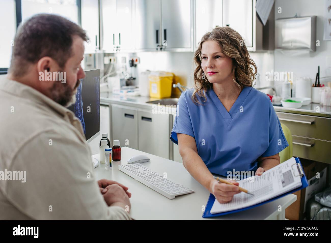 Consulenza medica con paziente in sovrappeso, discussione dei risultati del test in studio medico. Concetto di rischi per la salute di eccesso e obesità. Foto Stock