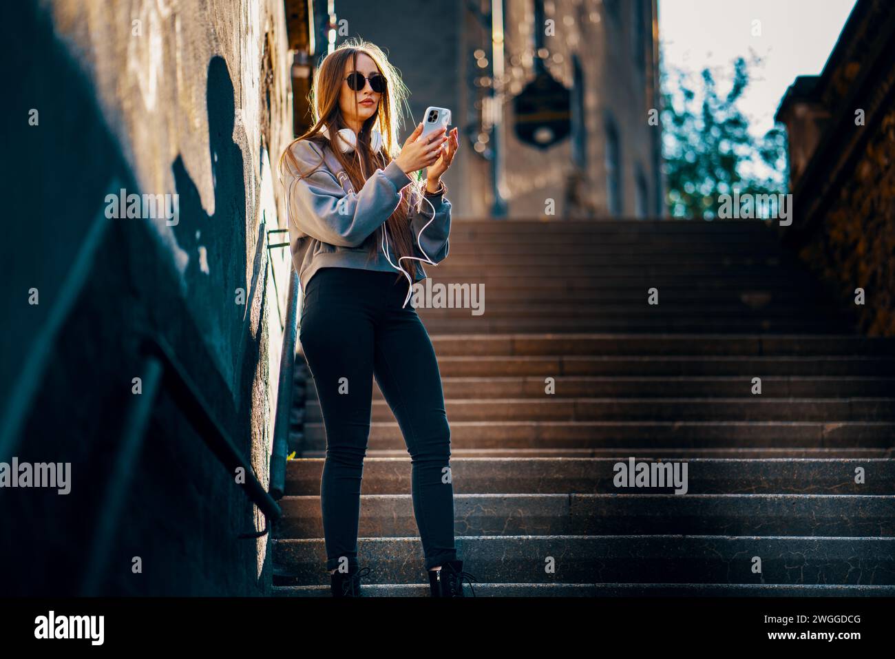 Donna urbana che usa lo smartphone sulla scalinata della città Foto Stock