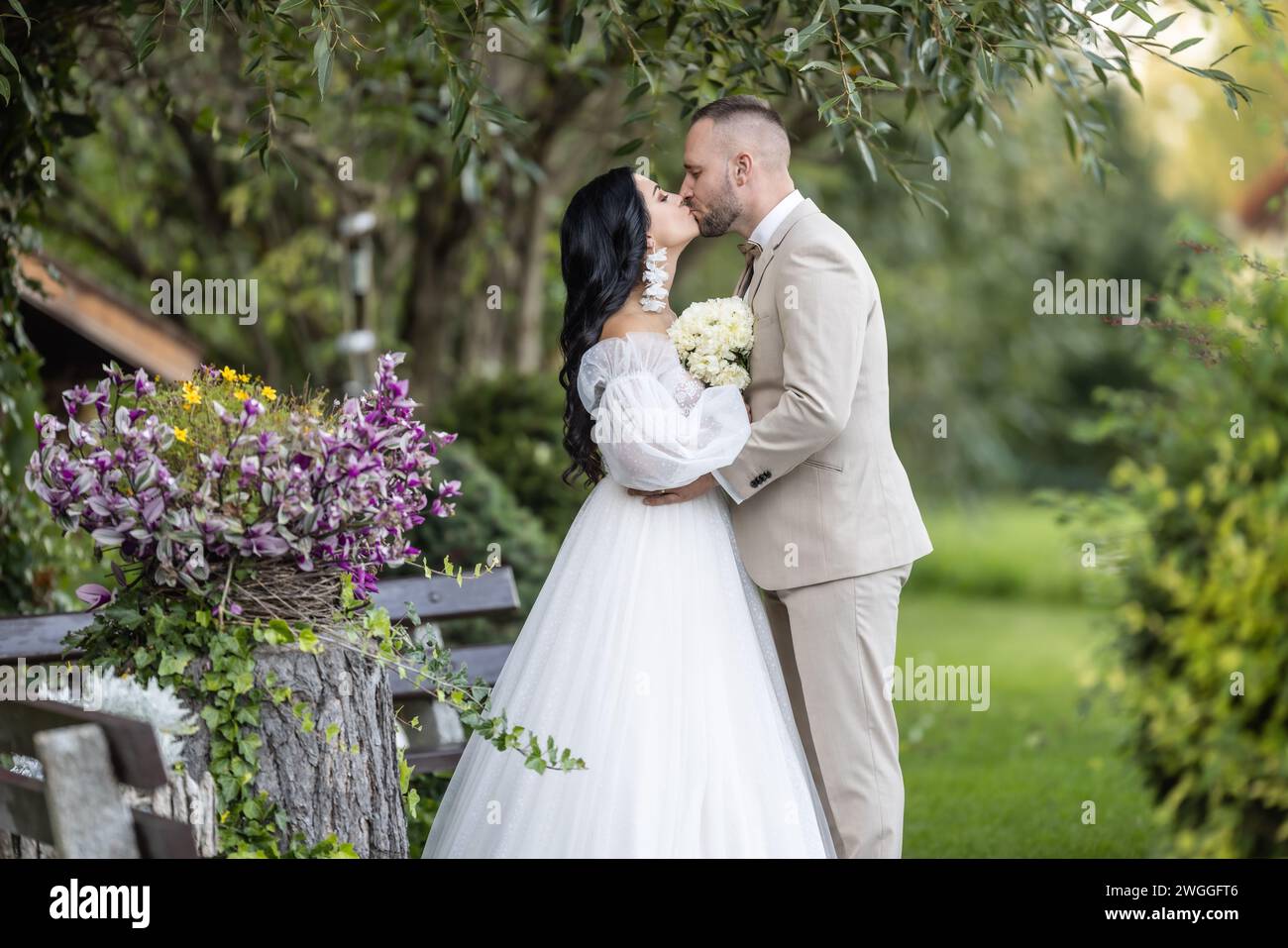 Gli sposi novelli si baciano dopo la cerimonia di nozze. Foto Stock