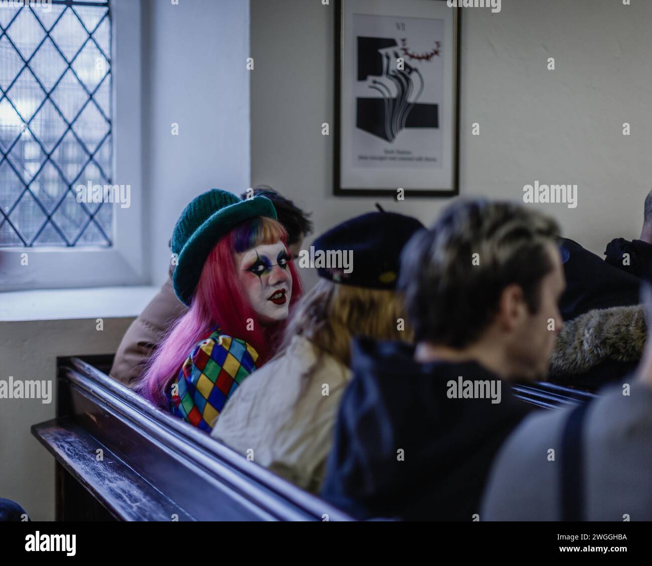 Un clown spicca nella congregazione in una chiesa londinese per celebrare Joseph Grimaldi. Foto Stock