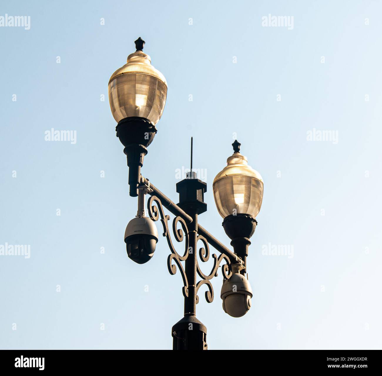 Una luce stradale solitaria che illumina la notte con la sua luce soffusa, emettendo una luce calda e invitante sulla strada vuota sottostante Foto Stock