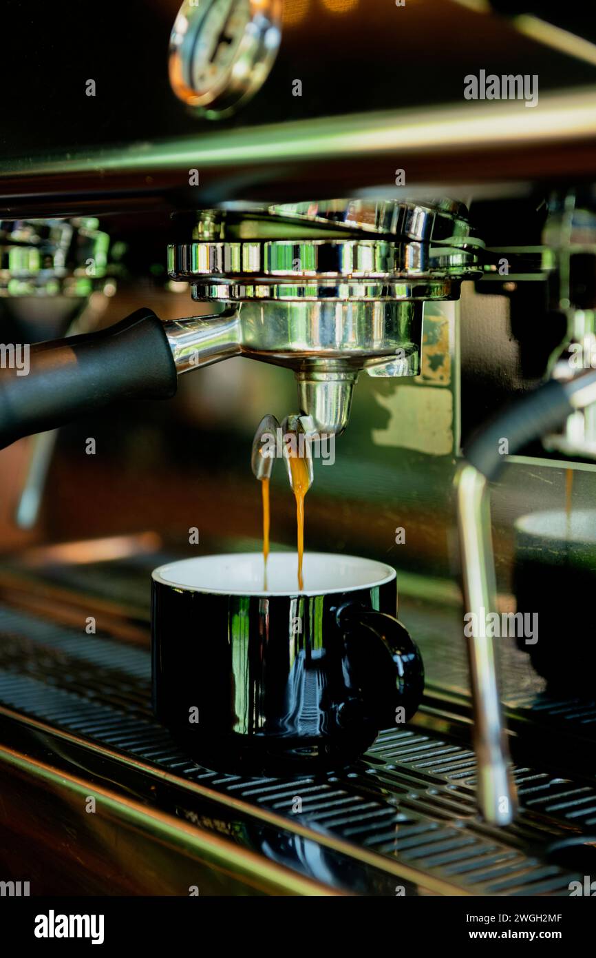 Primo piano del versamento dell'espresso dalla macchina per il caffè - foto stock Foto Stock
