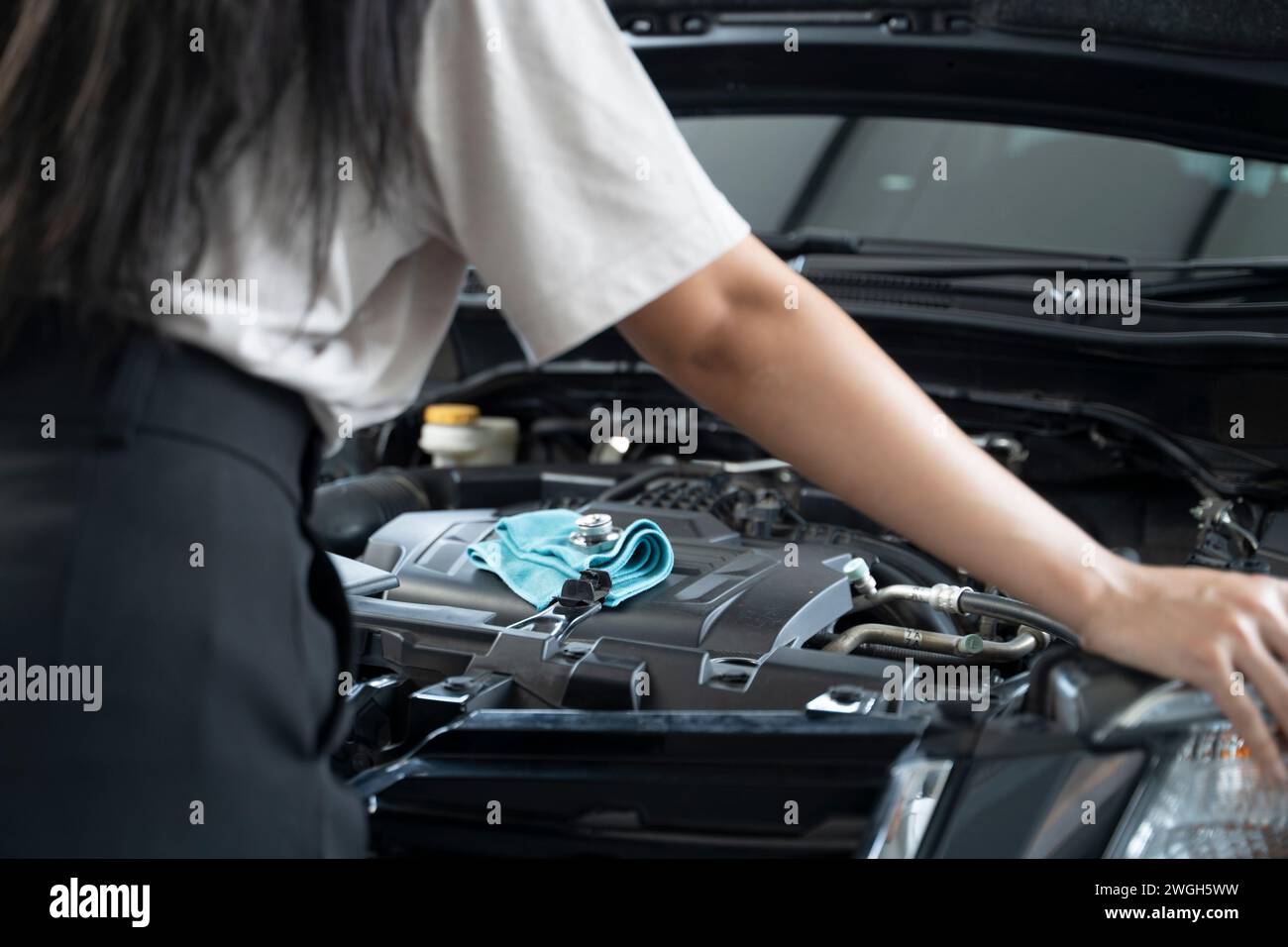 Donna asiatica che ha problemi con la sua auto bella donna che ispeziona la macchina rotta prima di uscire di casa. Foto Stock