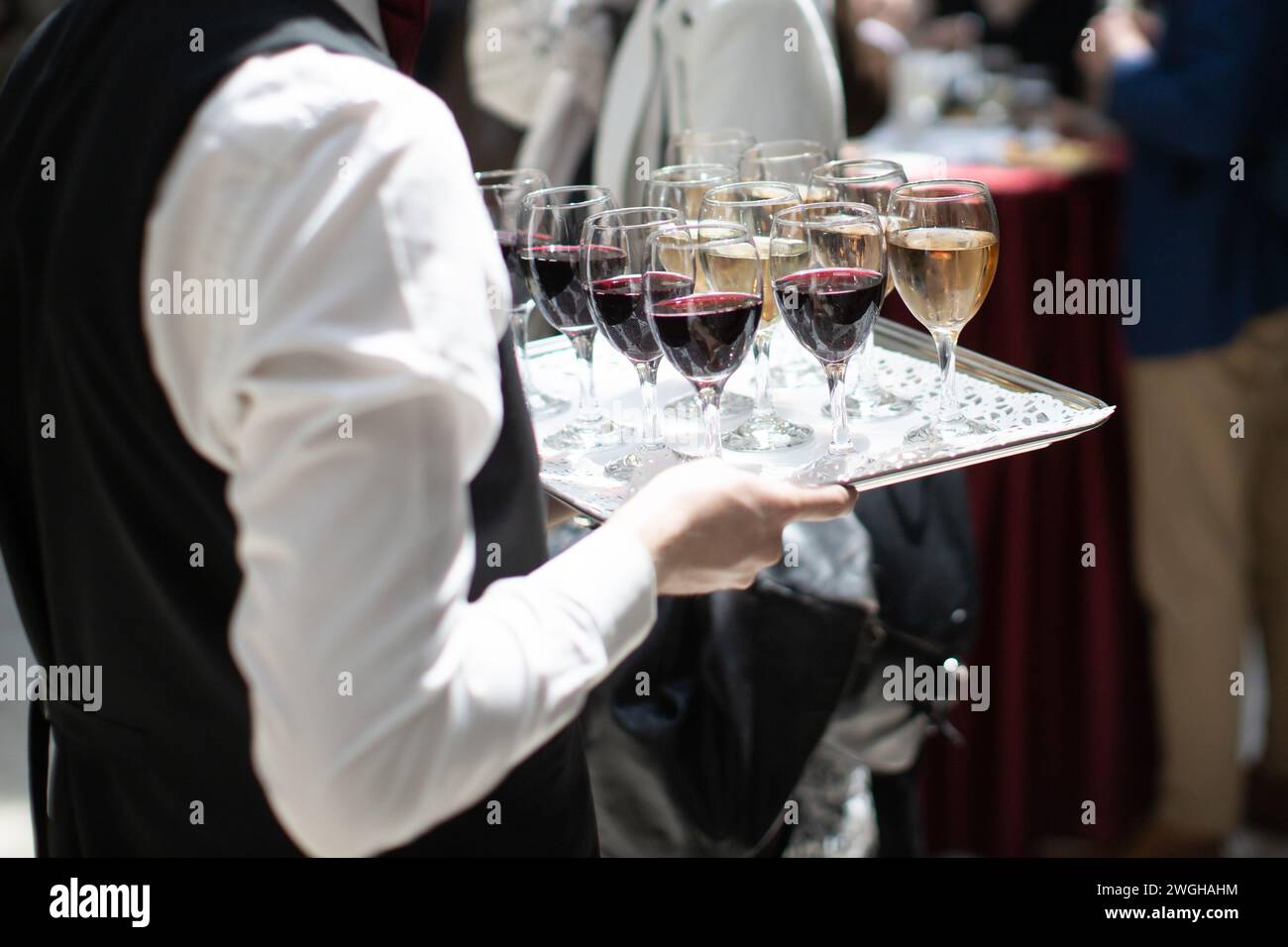 il cameriere serve vino alla festa Foto Stock