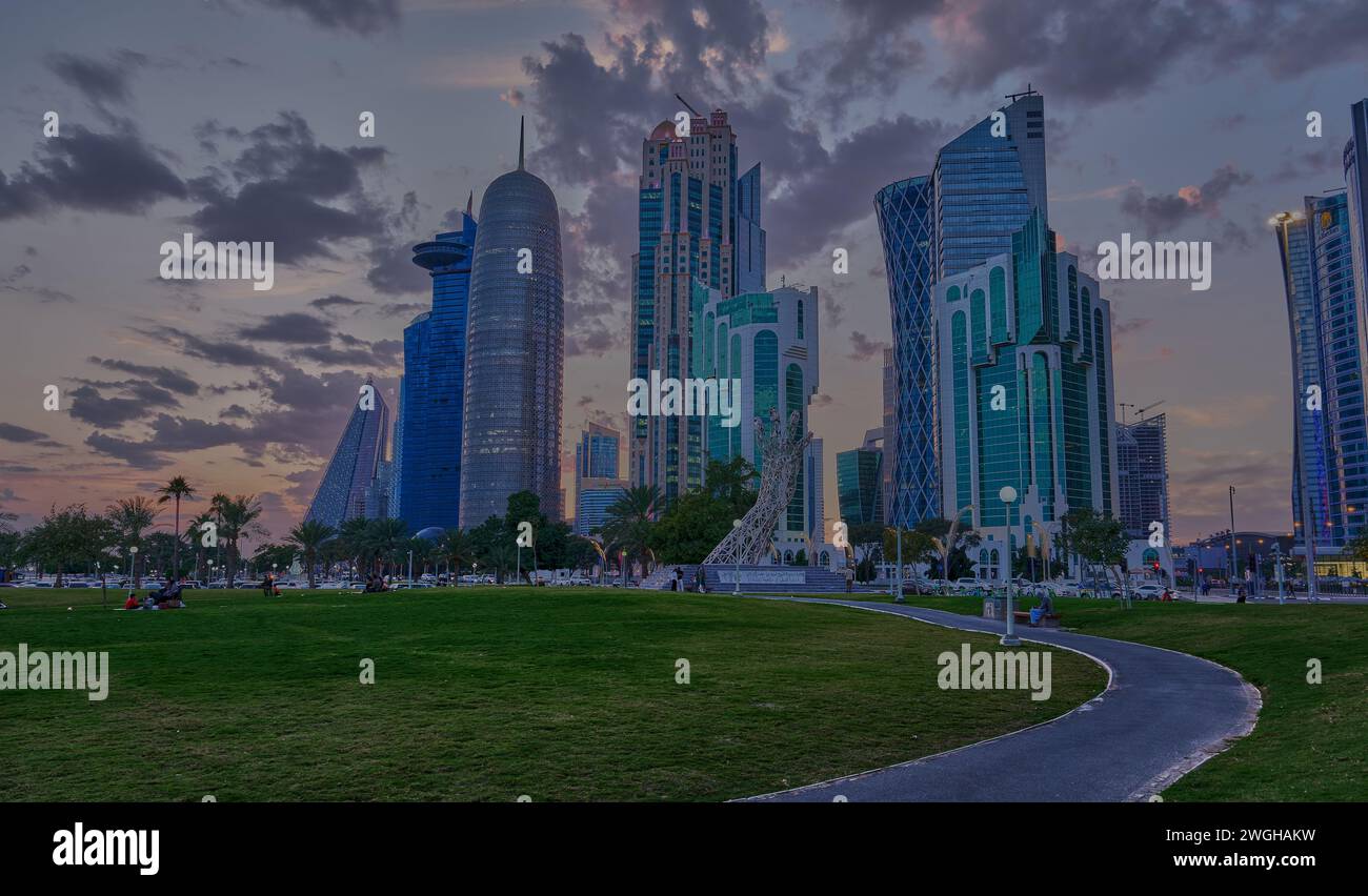 Lo skyline di Doha nella baia ovest è stato girato al tramonto dal parco dell'hotel con il monumento Sheikh Tamim Bin Hamad al-Thani International Anti Corruption Excellence Award Foto Stock