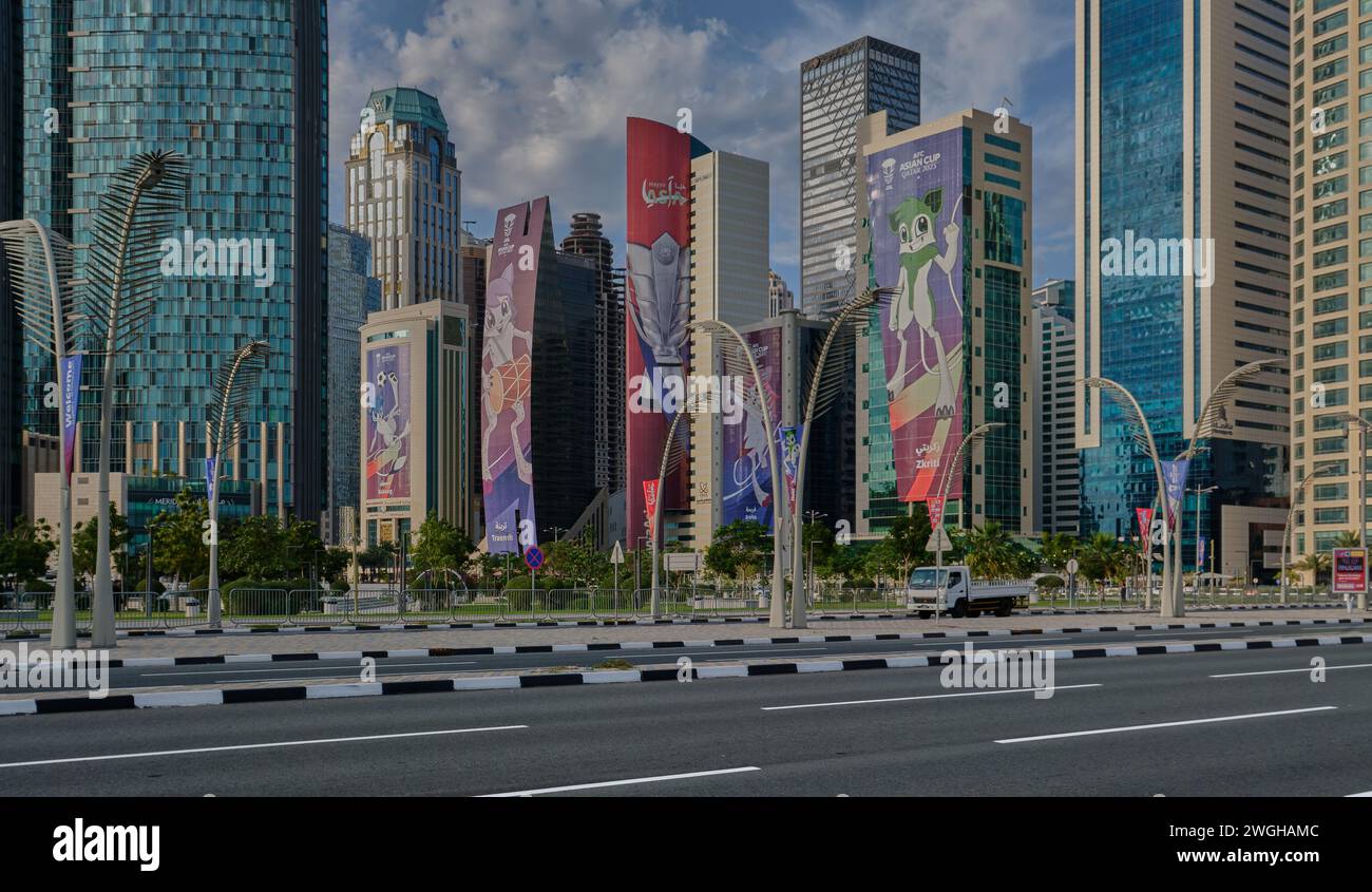 Skyline di Doha nel quartiere della West Bay Doha, Qatar pomeriggio girato con le mascotte della Coppa d'Asia 2023 AFC sugli edifici e le nuvole nel cielo Foto Stock
