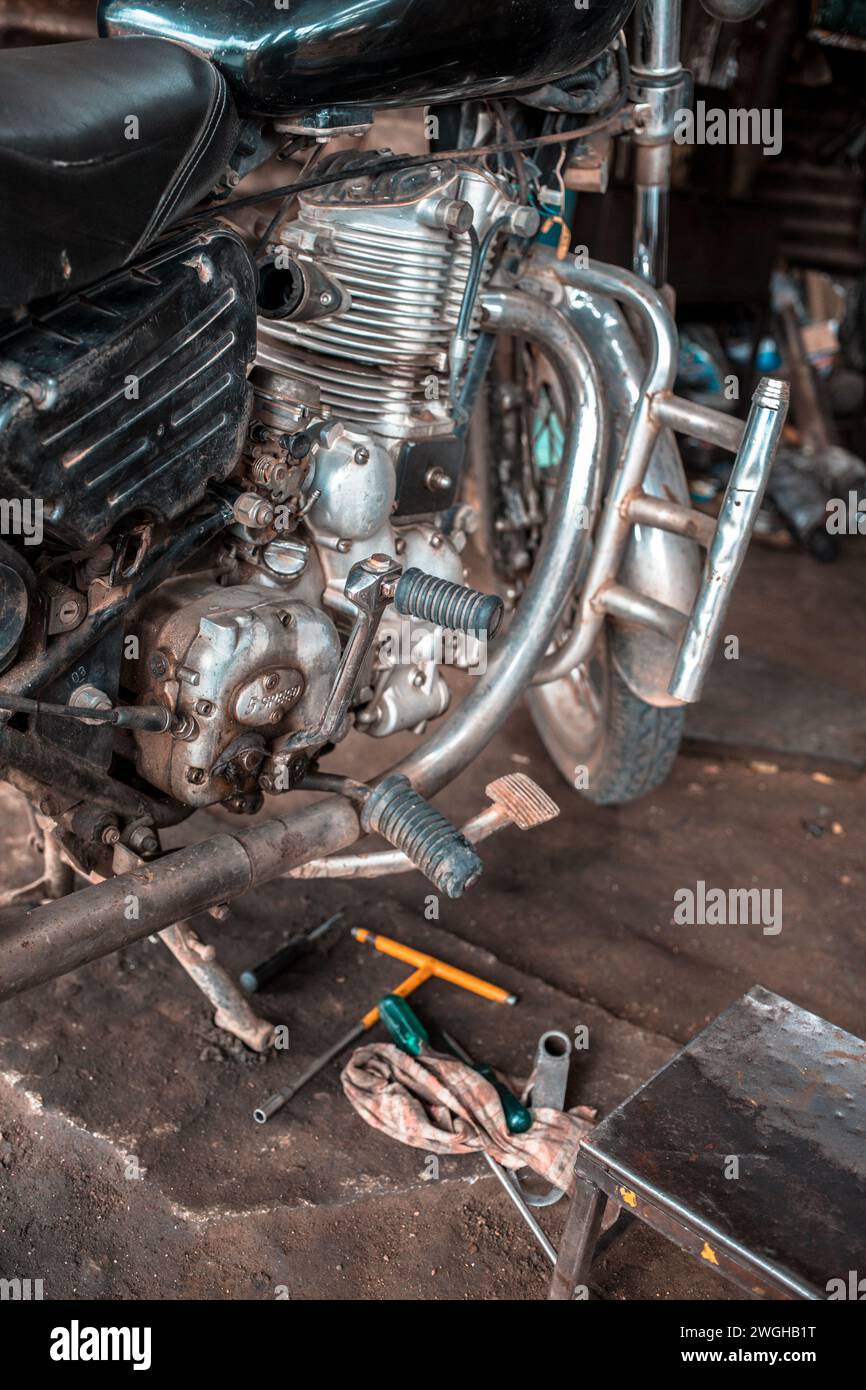 Una vecchia motocicletta che viene riparata in un garage. Foto Stock