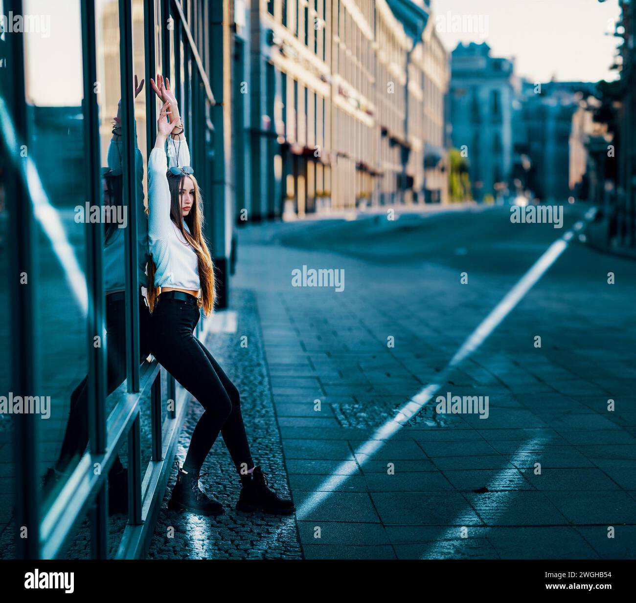 Giovane donna in City Street, ammira l'architettura sullo sfondo del Blue Sky Foto Stock
