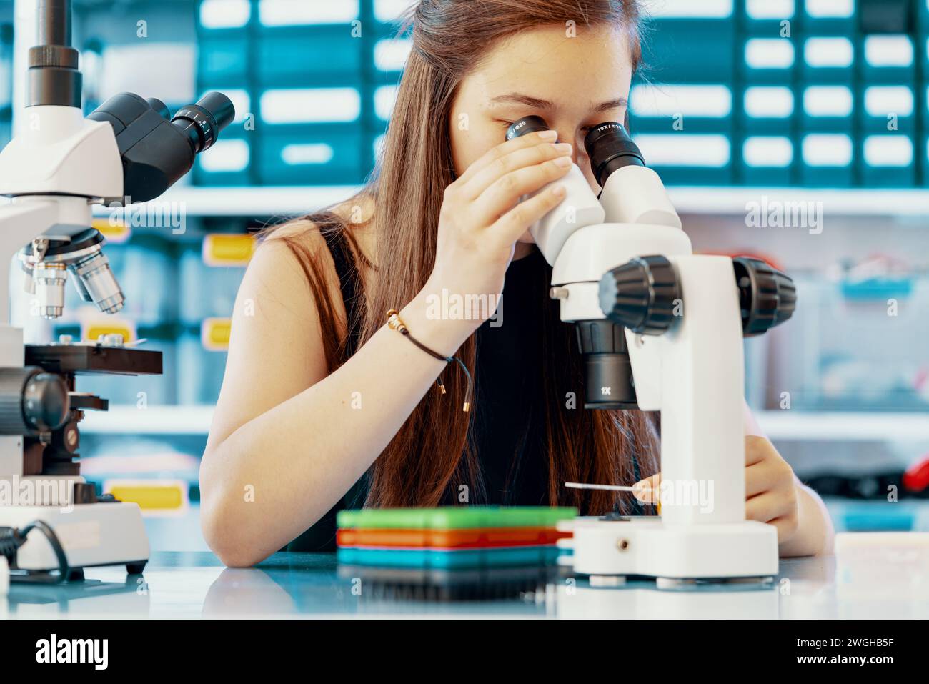 Giovane scienziata che conduce esperimenti scientifici in laboratorio Foto Stock