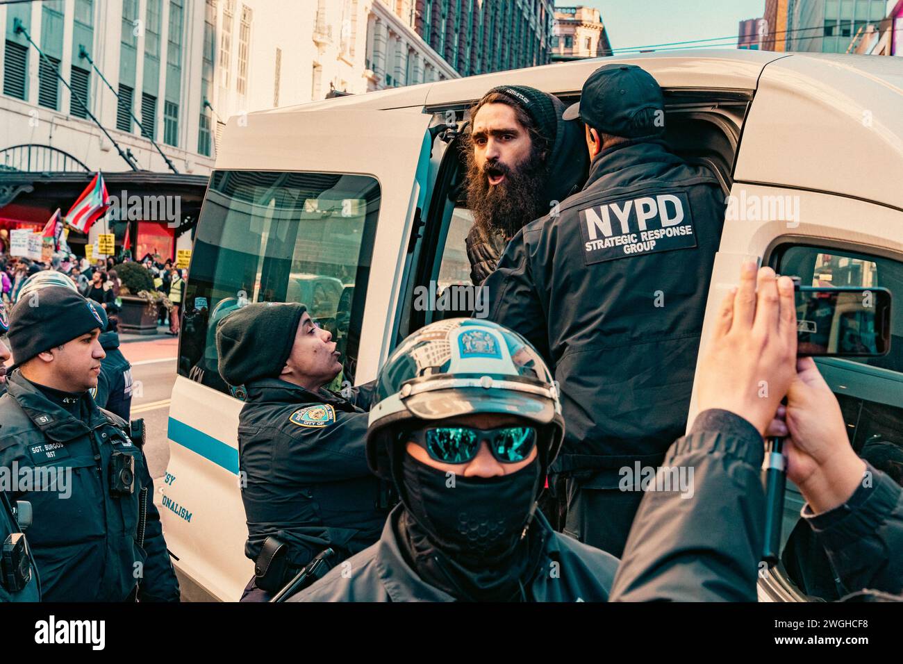 La polizia è vista fare arresti multipli dopo un breve ordine di dispersione per centinaia di manifestanti di liberare la strada a Midtown, Manhattan, New York, domenica 4 febbraio, 2024.le proteste settimanali a New York che chiedono un cessate il fuoco permanente a Gaza sono in corso da metà ottobre 2023. Chiede un cessate il fuoco dopo l'aggressiva risposta militare israeliana a un attacco contro circa 1.200 civili da parte di un gruppo militante palestinese e di un'autorità di governo, Hamas. La polizia di New York ha recentemente aumentato le direttive per mantenere le proteste sul marciapiede al fine di prevenire l'interruzione del traffico stradale. (Foto di Cristi Foto Stock