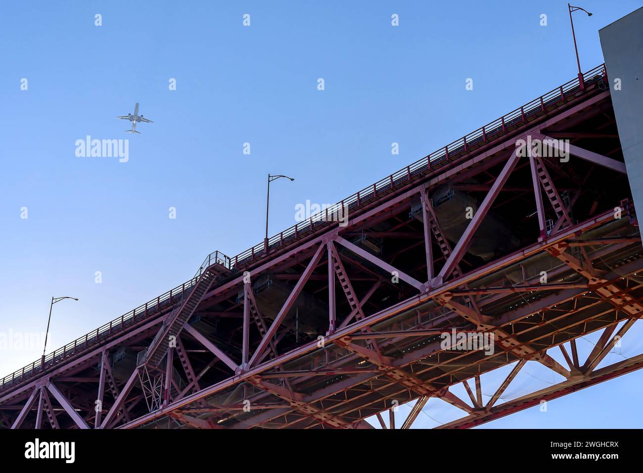 Un aereo passeggeri che sorvola il ponte 25 de Abril, Lisbona, Portogallo - 5 gennaio 2023 Foto Stock