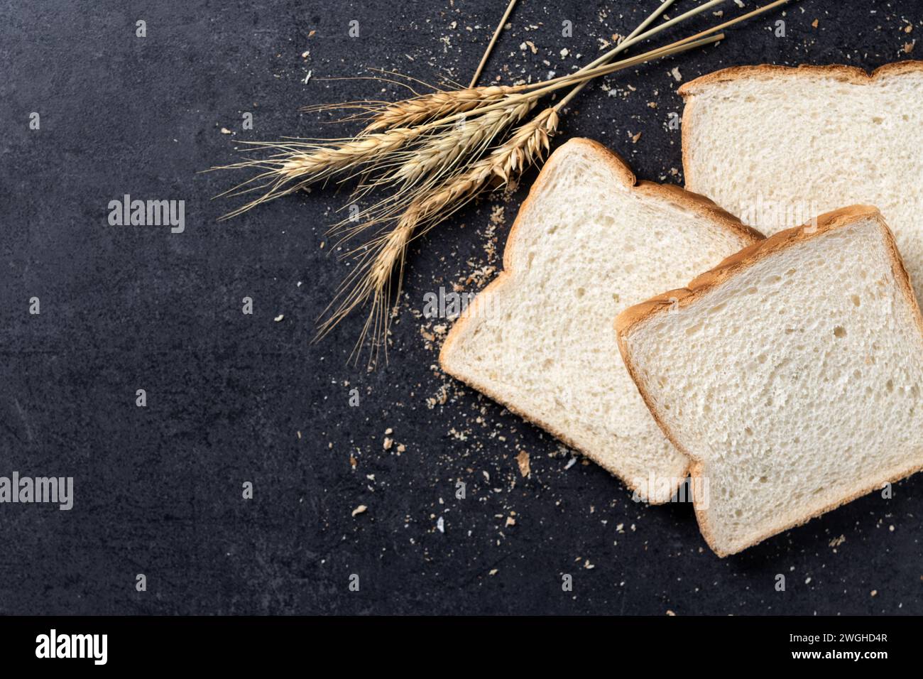 Pane bianco a fette su sfondo di ardesia nera. Vista dall'alto. Copia spazio Foto Stock