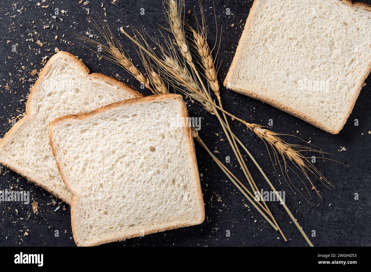 Pane bianco a fette su sfondo di ardesia nera. Vista dall'alto. Copia spazio Foto Stock