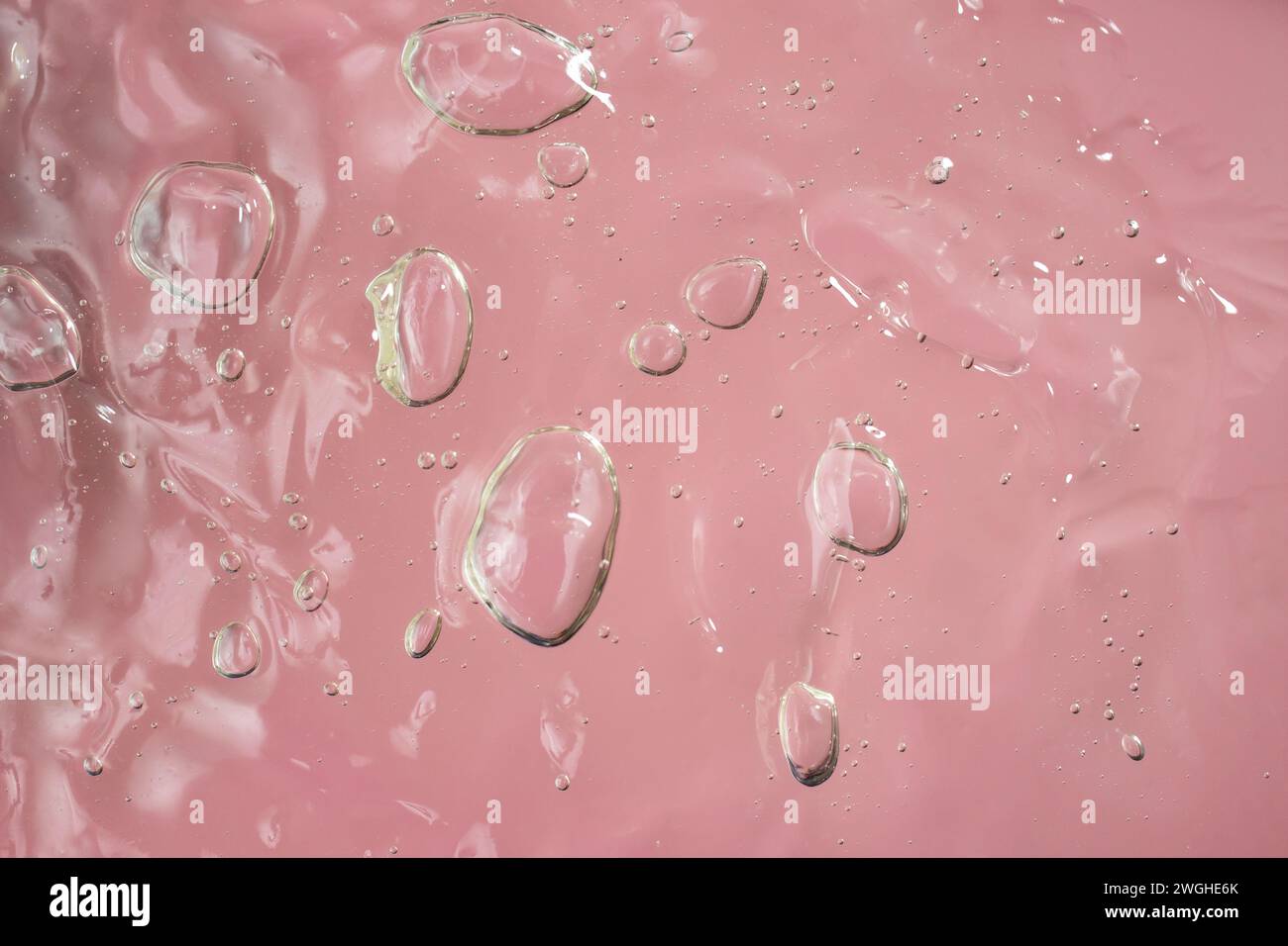 struttura in gel su sfondo rosa, sfondo per prodotti cosmetici, messa a fuoco morbida Foto Stock