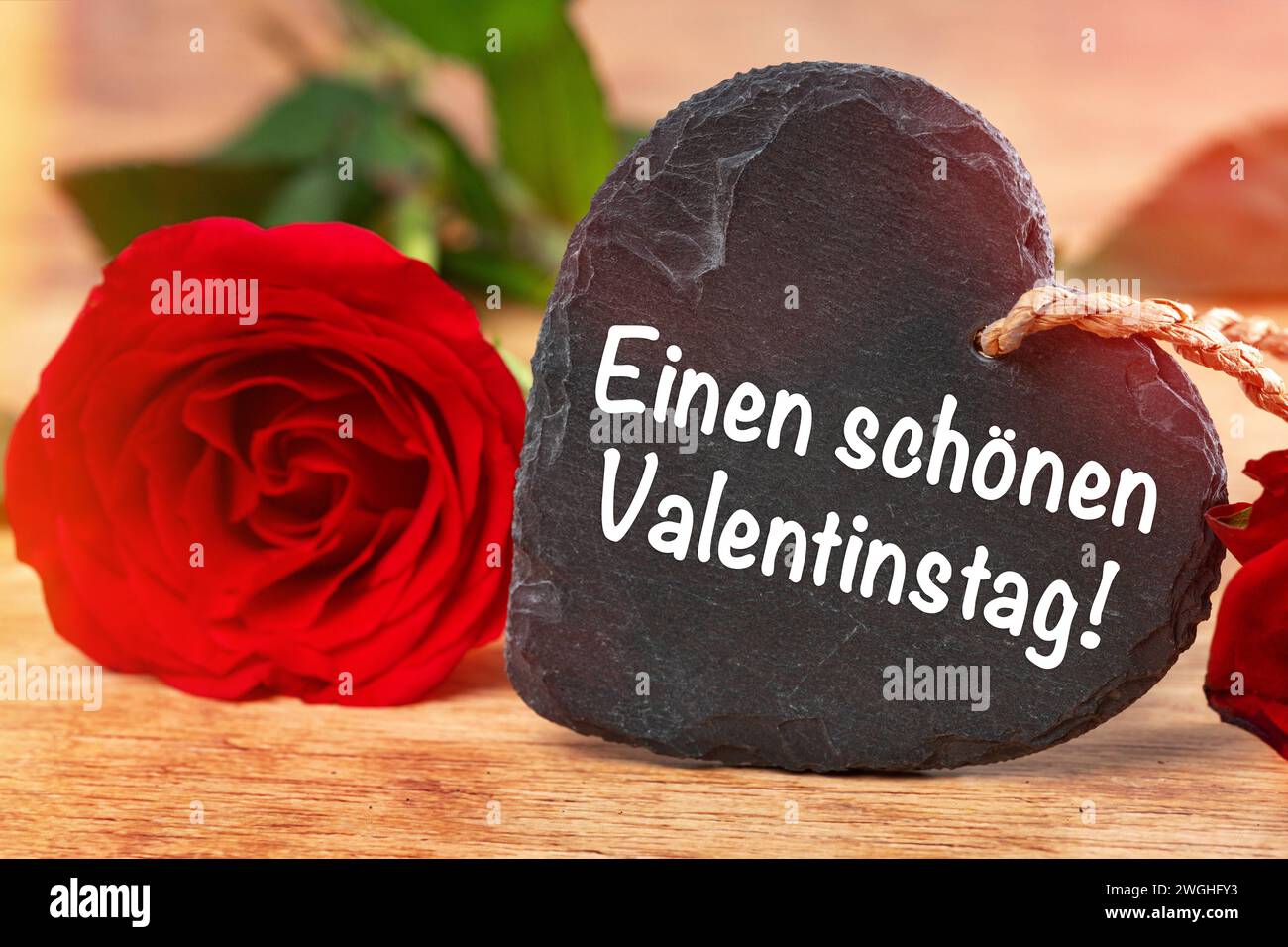 5 febbraio 2024: Buon San Valentino saluti su un cuore accanto a una rosa rossa FOTOMONTAGE *** einen schönen Valentinstag Grüße auf einem Herz neben einer roten Rose FOTOMONTAGE Foto Stock