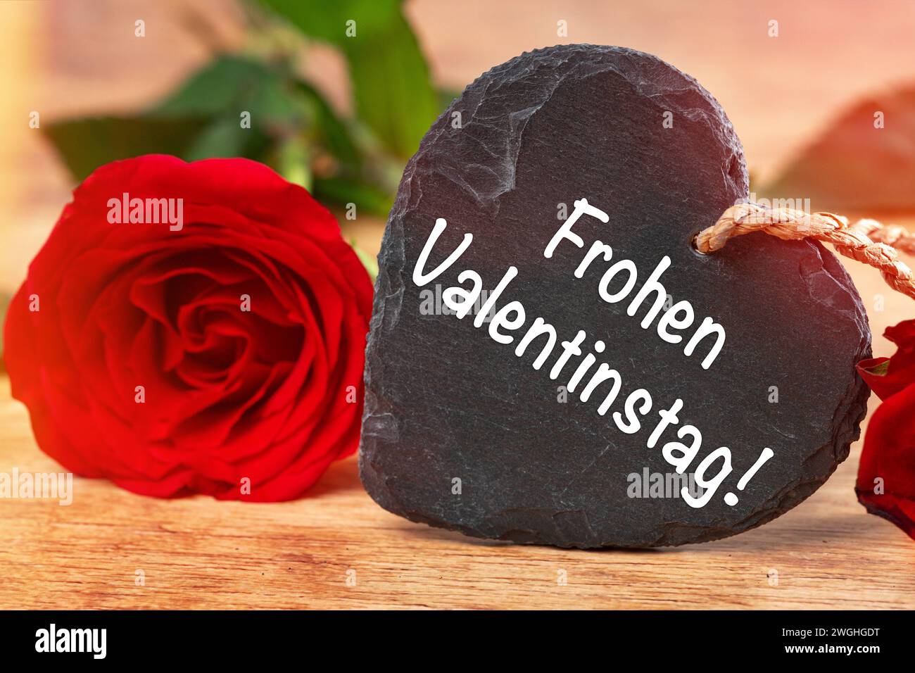 5 febbraio 2024: Buon San Valentino saluto su un cuore accanto a una rosa rossa. FOTOMONTAGGIO *** Frohen Valentinstag Gruß auf einem Herz neben einer roten Rose. FOTOMONTAGE Foto Stock