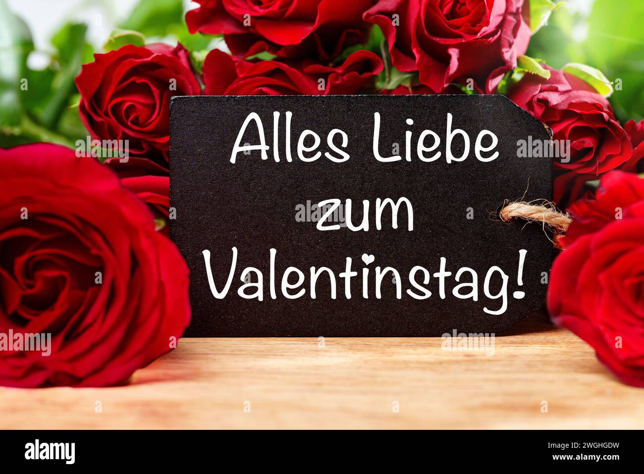 5 febbraio 2024: Tutto l'amore per San Valentino saluto su un cartello di fronte alle rose rosse FOTOMONTAGE **** Alles Liebe zum Valentinstag Gruß auf einem Schild vor roten Rosen FOTOMONTAGE Foto Stock