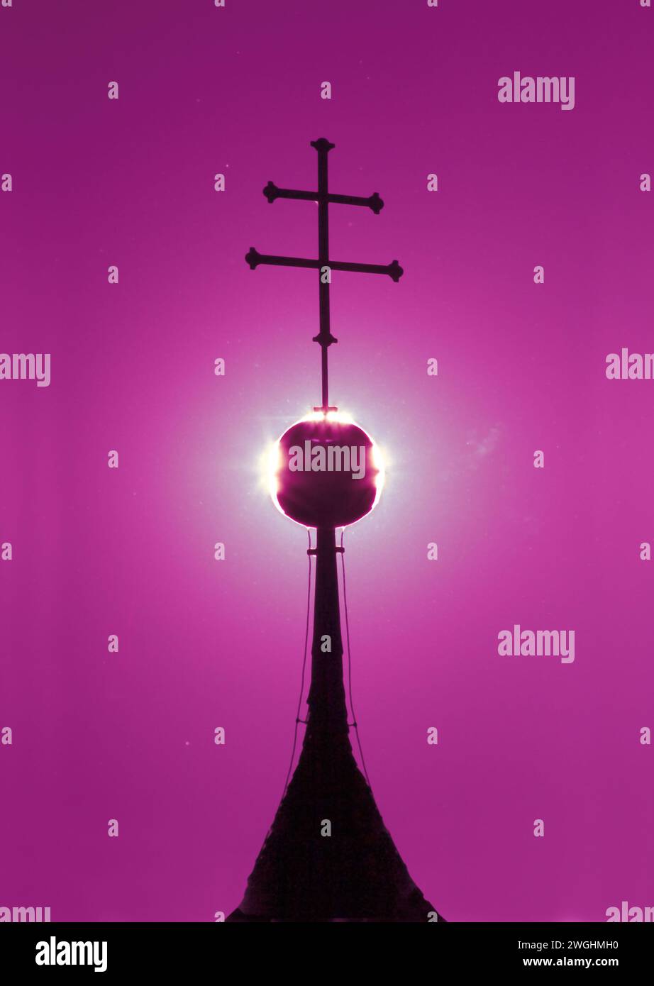 Una croce retroilluminata sulla sommità della torre di una chiesa cattolica, Baviera, Germania Foto Stock