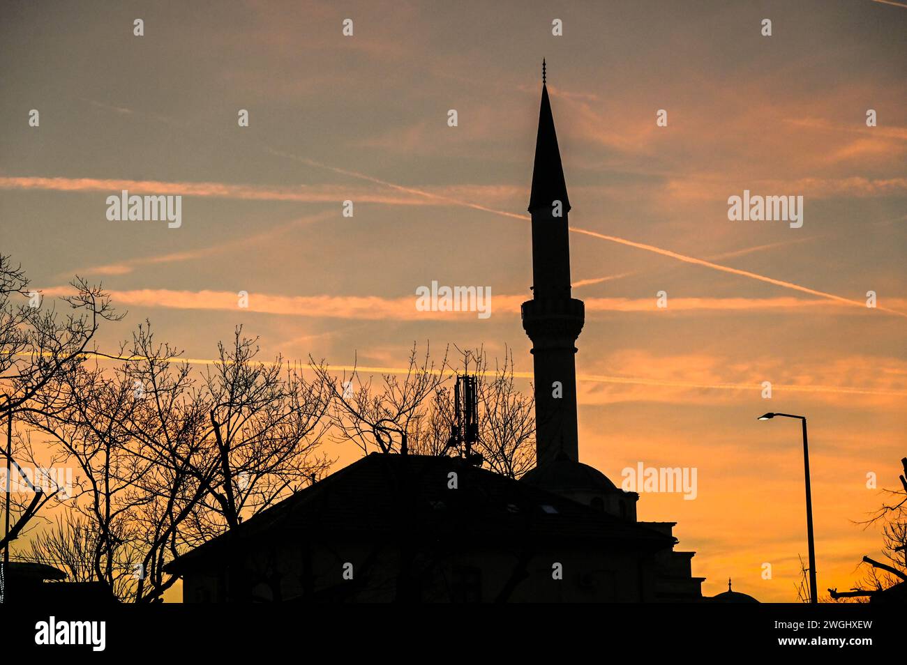 Sagoma del minareto e della moschea al tramonto. Simbolo dell'Islam. Foto Stock