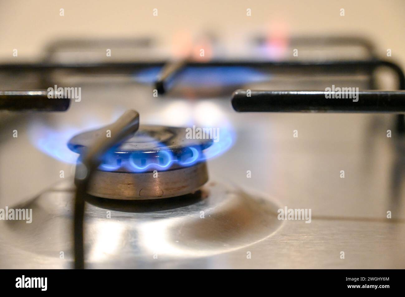 Fornello a gas in cucina. Fiamme blu sul fornello a gas in casa. Primo piano del fuoco incendiato sul fornello a gas propano. Foto Stock