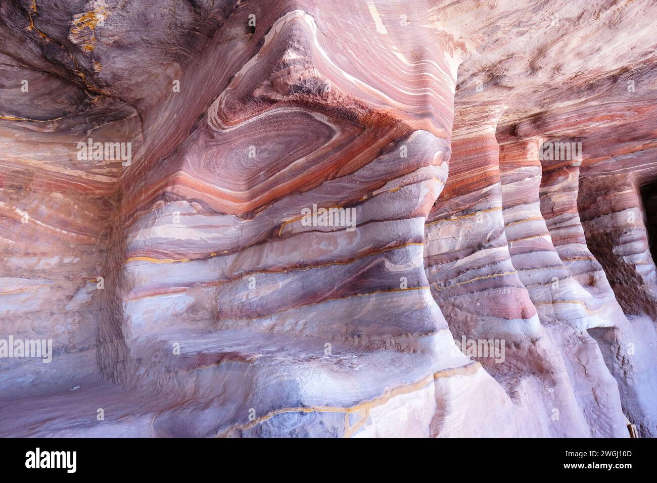Petra Jordan - all'interno della Tomba della Seta che mostra i suoi variopinti vortici di roccia nell'antico sito nabateo nell'agosto 2023 Foto Stock