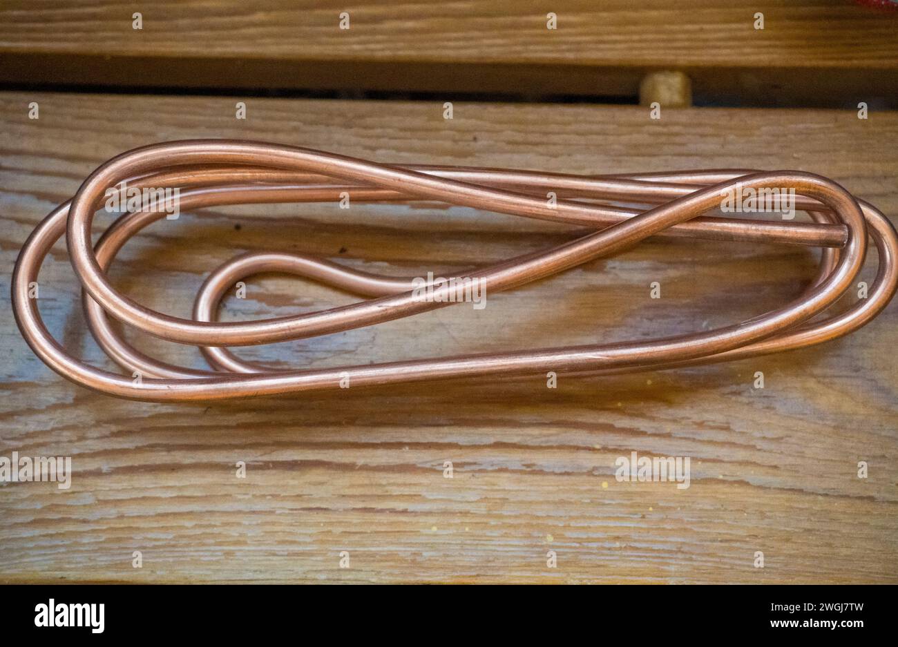 Filo di rame su sfondo in legno, focalizzazione selettiva grande di filo di rame arancione Foto Stock