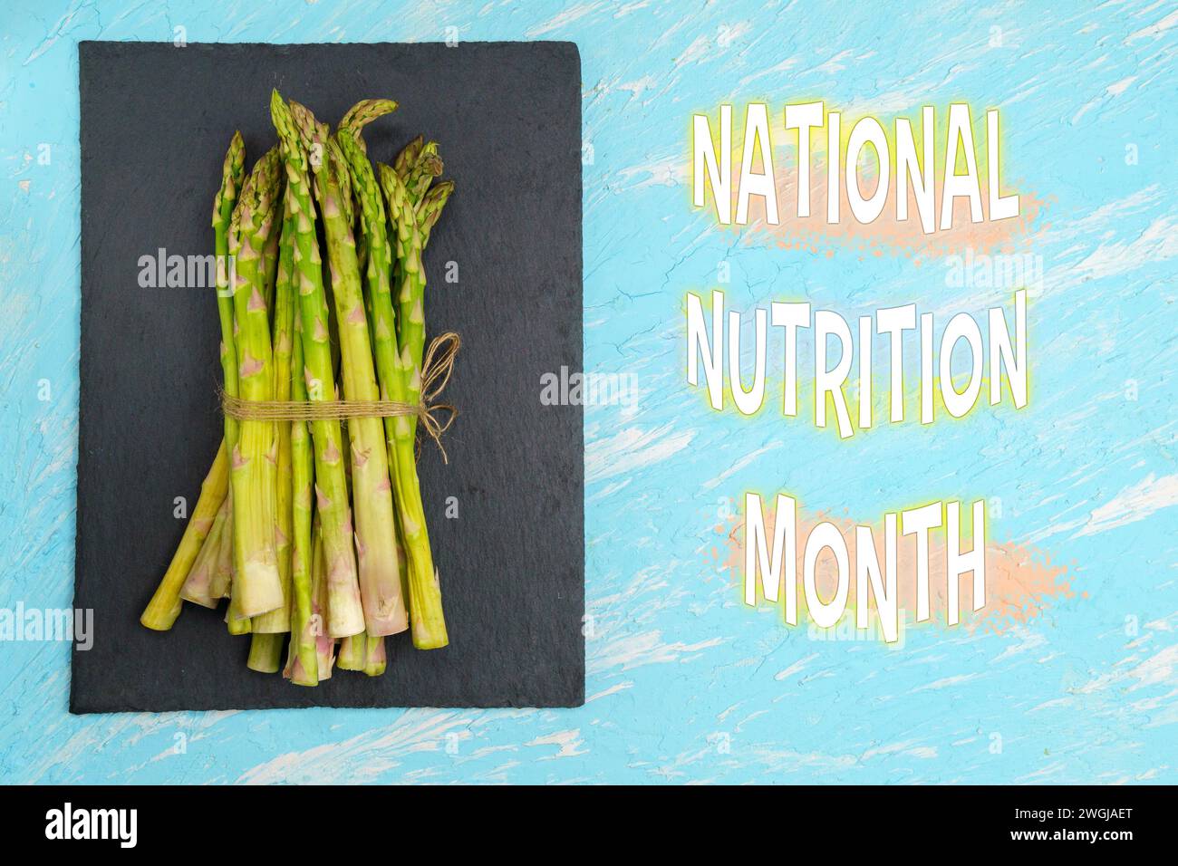 Festeggiamo il mese della Nutrizione nazionale con asparagi freschi sullo sfondo ardesia Foto Stock