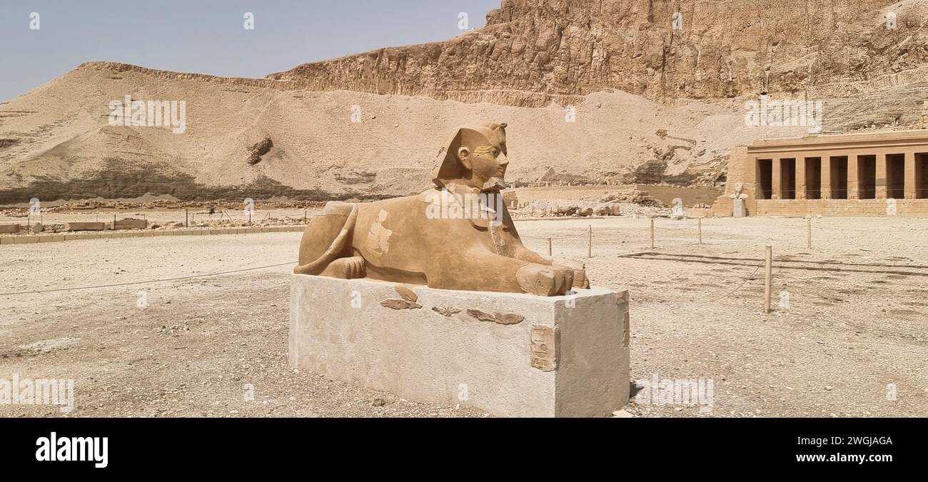 Un'antica statua in pietra egiziana con maestoso sfondo di montagna Foto Stock