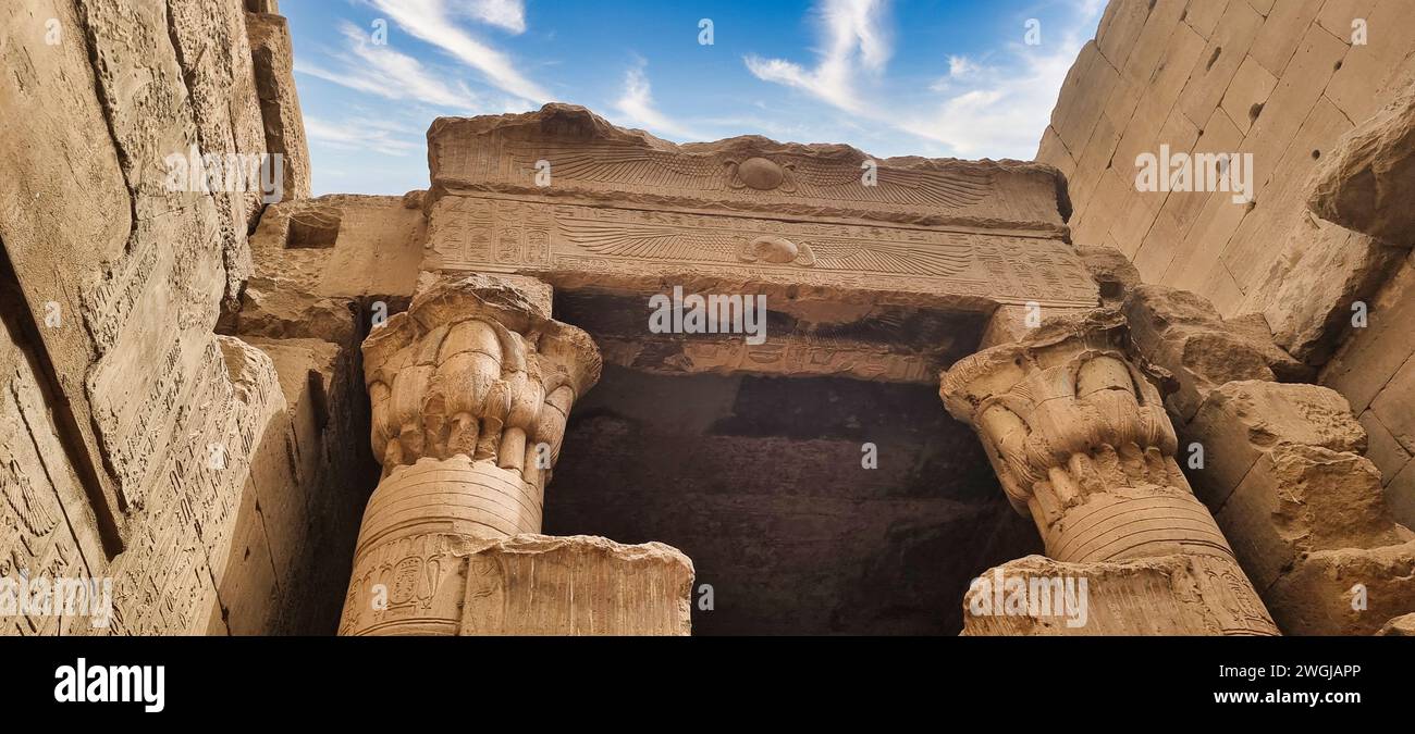 Due colonne di pietra ornate con intricate incisioni, adagiate su un cielo blu vibrante Foto Stock