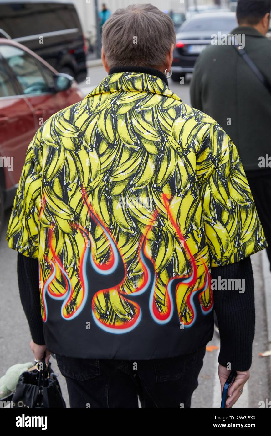 MILANO, ITALIA - 14 GENNAIO 2024: Uomo con giacca con design banana e fiamme prima della sfilata Prada, Milano Fashion Week Street style Foto Stock