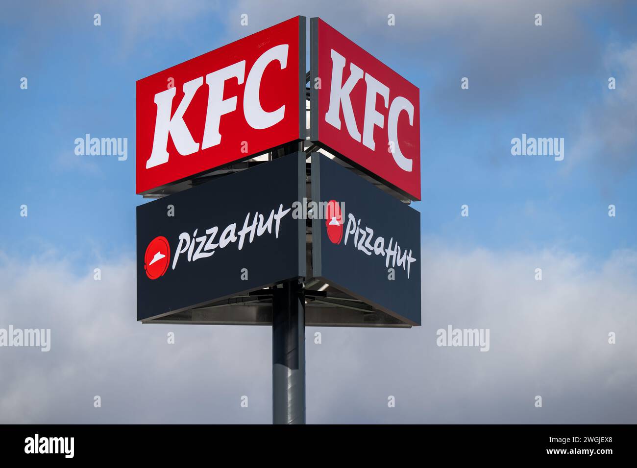 , Food, Deutschland, Baden-Württemberg, Hockenheim, 05.02.2024, KFC und Pizza Hut Werbetafeln mit Fahnen gegen Himmel. Foto Stock