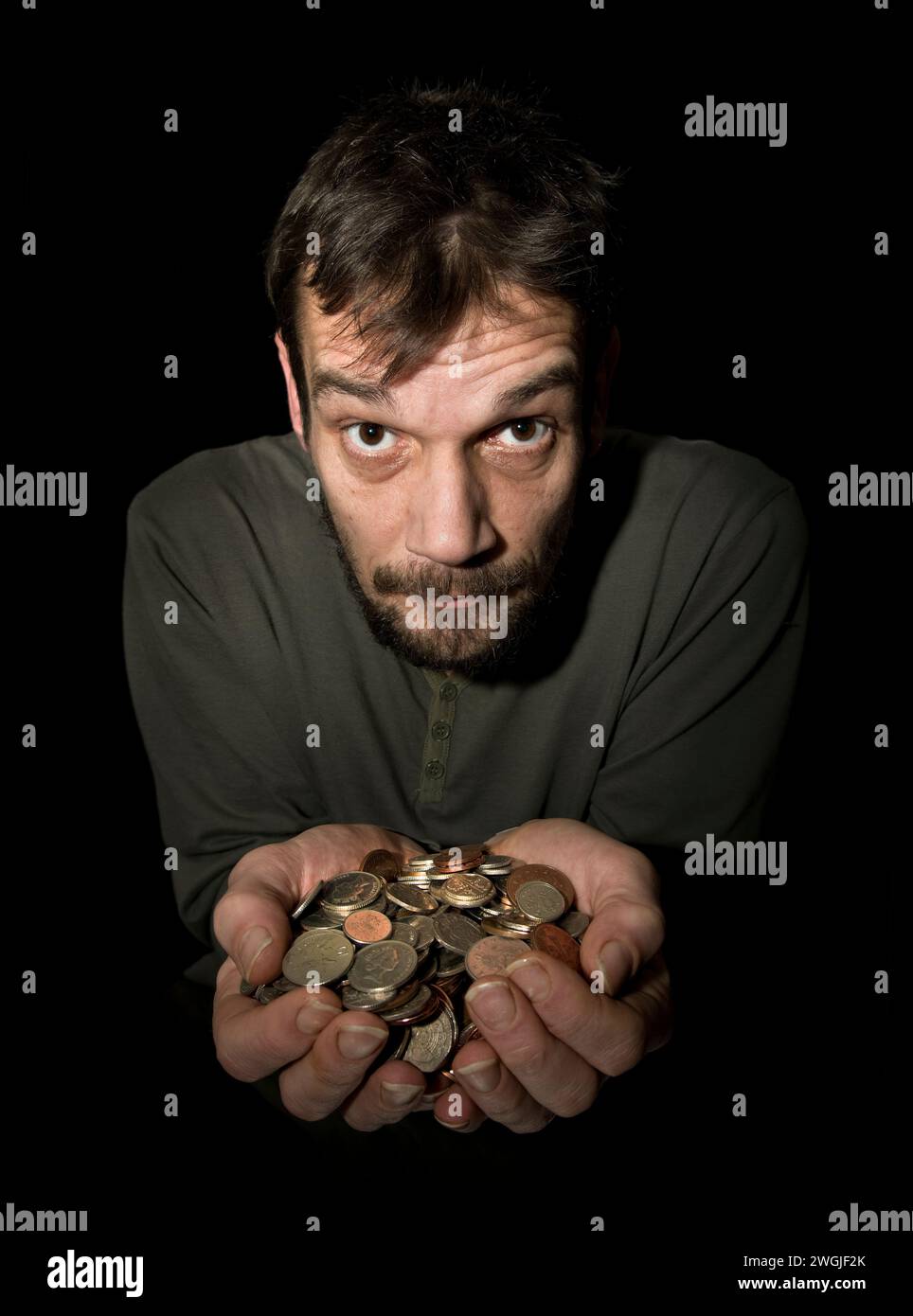 Maschio caucasico (42 anni) con le mani tenute in disparte pieno di cambiamenti nella valuta della sterlina, con il volto rivolto verso l'alto come se non riuscisse a credere alla sua Foto Stock