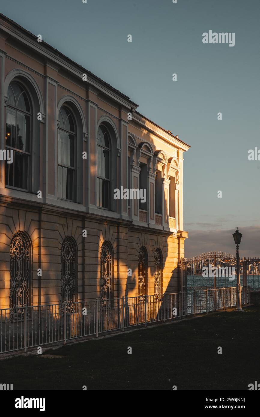 Uno splendido edificio vicino ad un tranquillo lago si riflette splendidamente nei colori vibranti del tramonto a Istanbul, Turchia Foto Stock