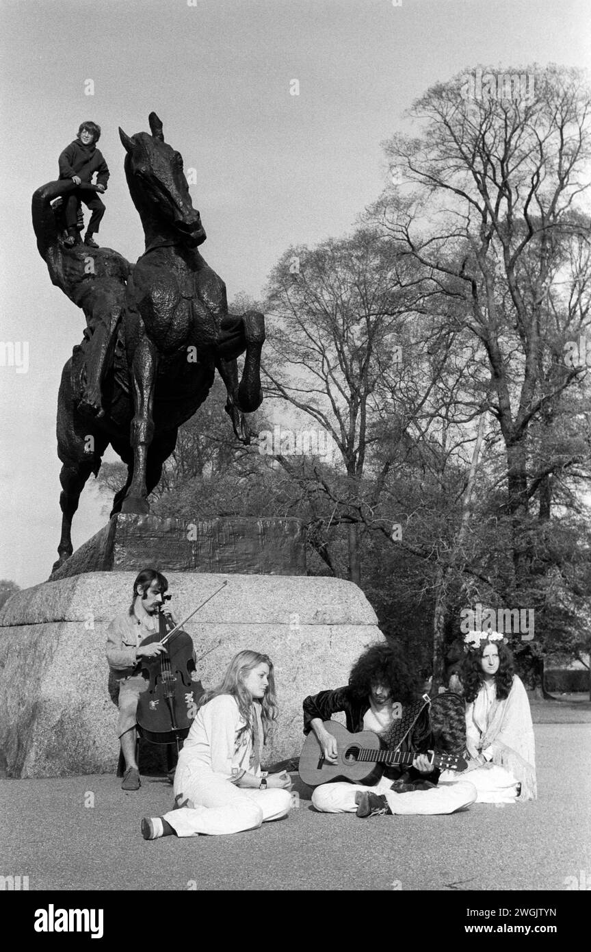 Flower Power 1970s hippies Regno Unito. Kensington Gardens che fa musica sotto la statua dell'energia fisica, di George Frederick Watts. Kensington, Londra. 1971 Inghilterra HOMER SYKES Foto Stock