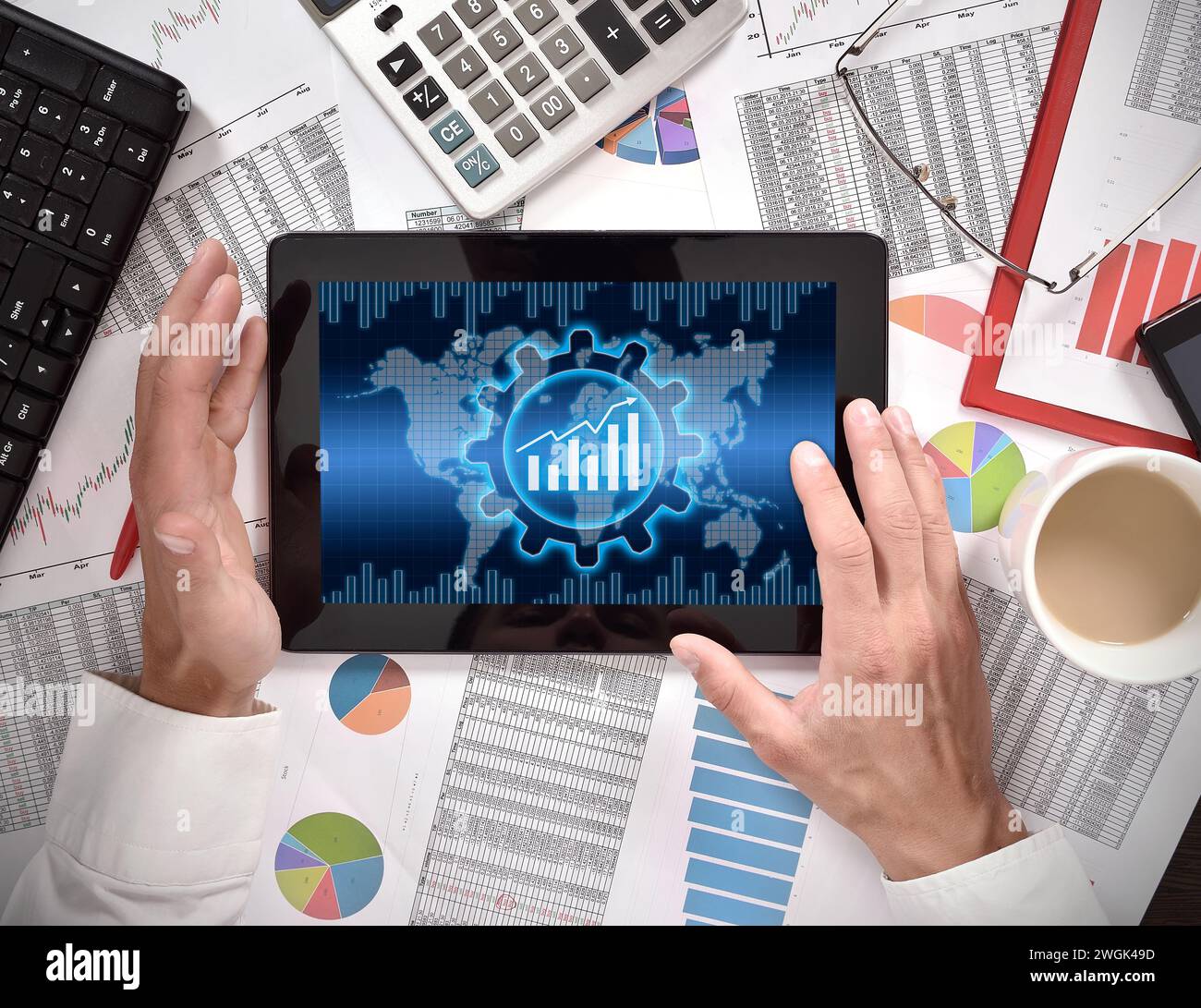 L'uomo d'affari utilizza un tablet con dati analitici e un'interfaccia aziendale globale. Commercio e finanza. Vista dall'alto Foto Stock