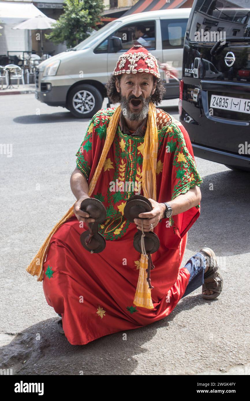 Un musicista per le strade di Tangeri, un porto marocchino sullo stretto di Gibilterra, è stato un punto di accesso strategico tra l'Africa e l'Europa fin dai tempi dei Fenici. La sua medina bianca sulle colline ospita il Dar el Makhzen, un palazzo dei sultani che ora è un museo di manufatti marocchini. L'American Legation Museum, sempre nella medina, documenta le prime relazioni diplomatiche tra gli Stati Uniti e il Marocco in un ex consolato in stile moresco del 1821. Marocco. Foto Stock