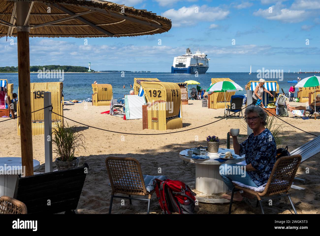 Sommer Strandleben mit Strandkörben an der Kieler Förde in Möltenort, Die Maxi Fähre Color Fantasy fährt vorbei Foto Stock