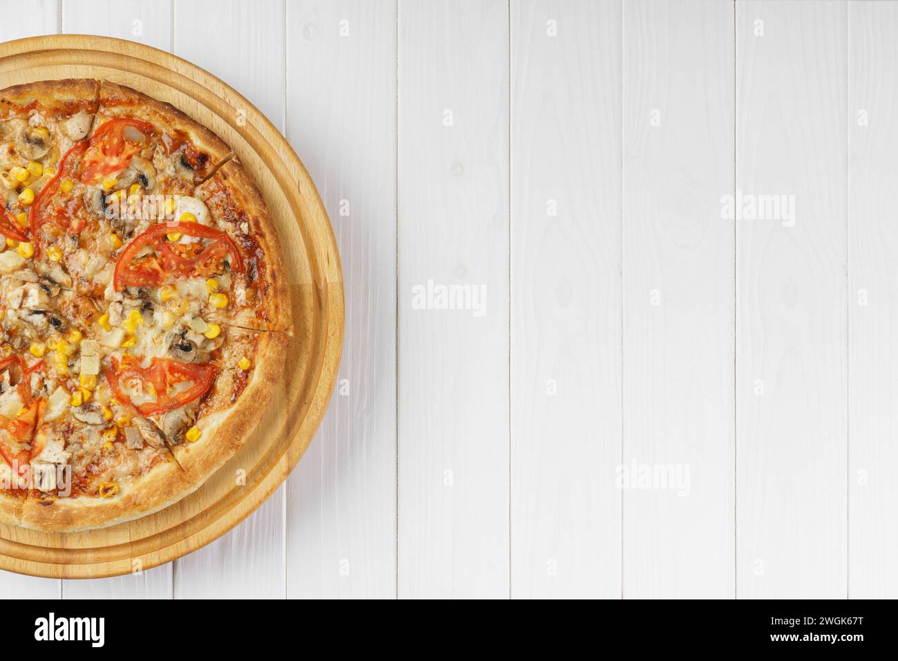 Pizza italiana fatta in casa con funghi di mozzarella, mais e pomodoro su un piatto rotondo di legno su sfondo bianco di legno. Banner, intestazione con c Foto Stock