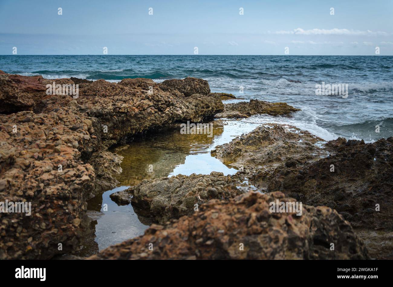 Onde marine su una costa rocciosa nel Parco naturale della Sierra de Irta, Castellon, Spagna Foto Stock