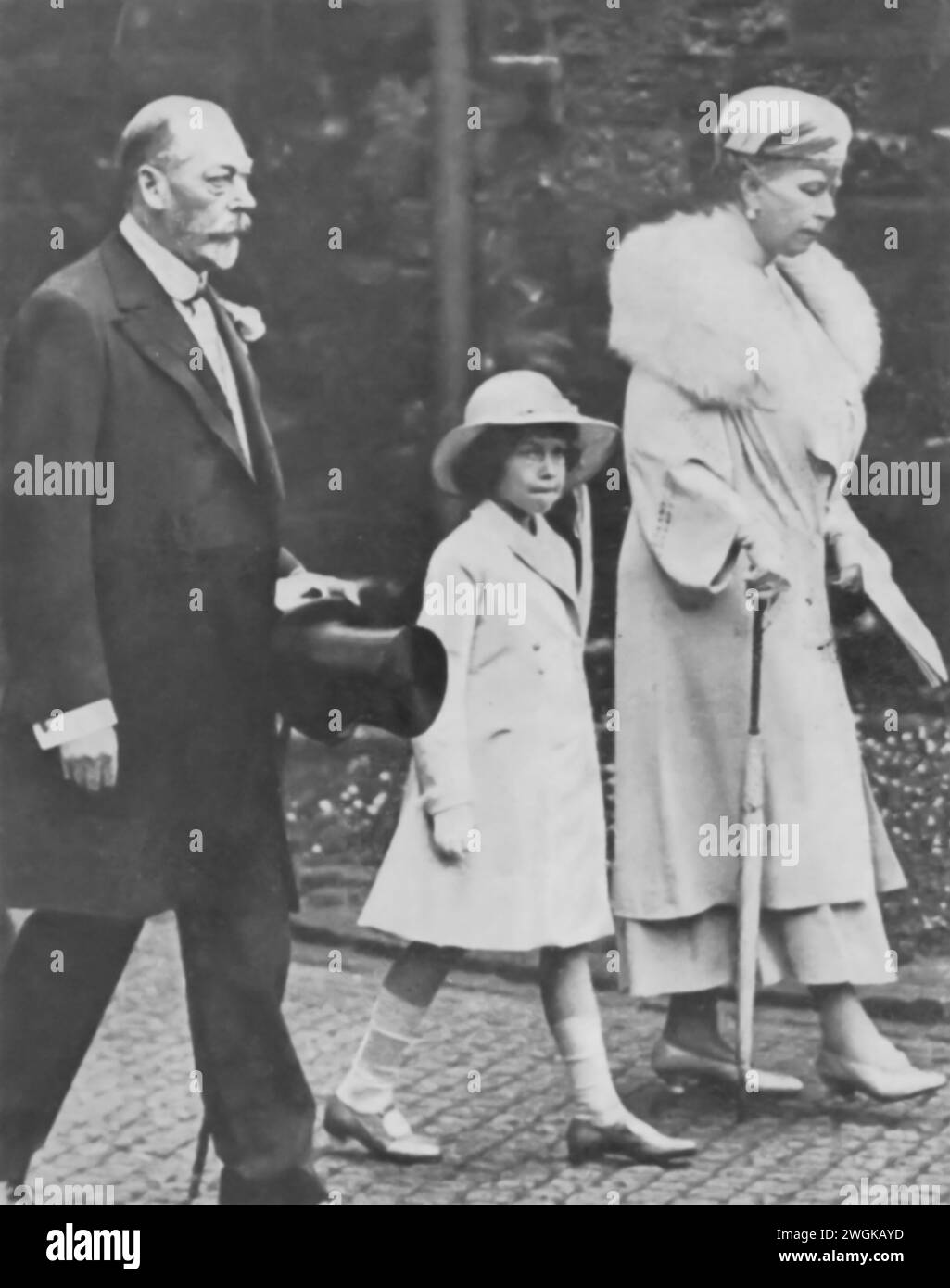 Fotografia di una principessa Elisabetta II di 8 anni con i suoi nonni, re Giorgio V e la regina Maria, scattata nel 1934. Questa immagine cattura un momento con i monarchi regnanti, appena due anni prima della morte di re Giorgio V nel 1936, seguito dal breve regno di Edoardo VIII La fotografia offre uno sguardo storico sulla stirpe reale e sui primi anni di vita di Elisabetta, che era allora terza in linea al trono. Foto Stock