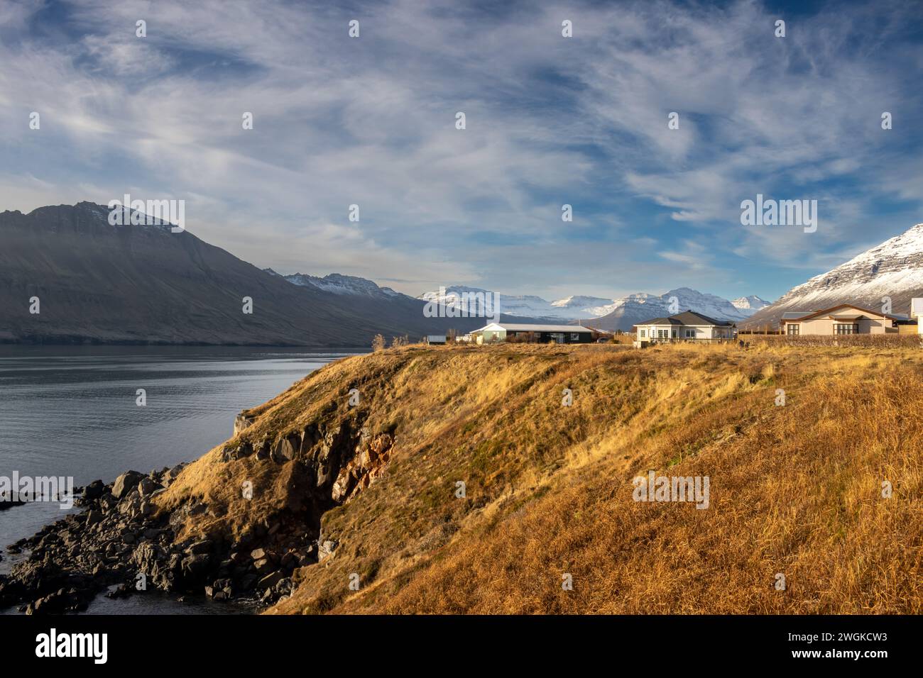 Case del piccolo paese, ha creato un costruito con buon gusto, senza disturbare la natura circostante. Piccola città sulla costa di un fiordo. Neskaupstadur, est Foto Stock Case del piccolo paese, ha creato un costruito con buon gusto, senza disturbare la natura circostante. Piccola città sulla costa di un fiordo. Neskaupstadur, est Foto Stock