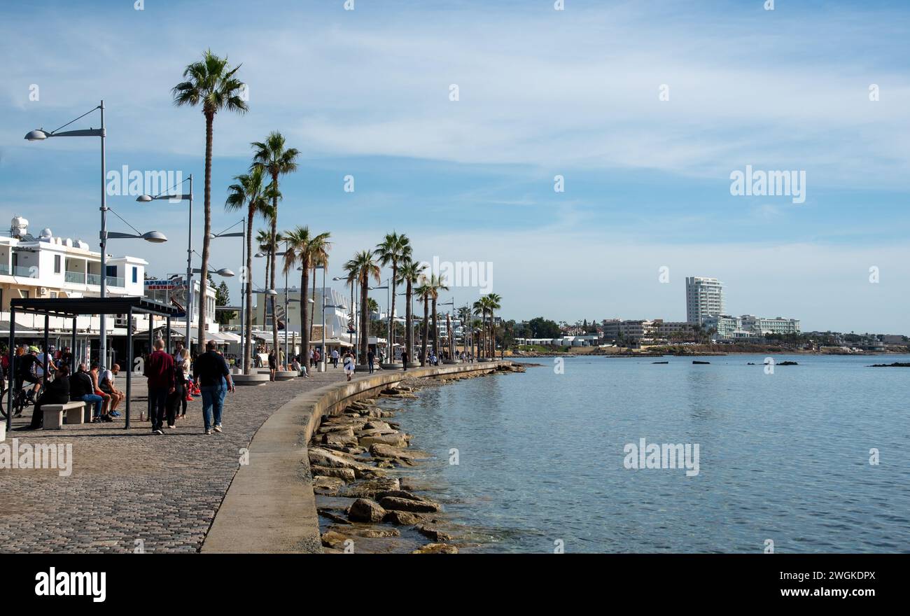 Turisti che camminano sul sentiero pedonale nel villaggio turistico di Kato Paphos a Cipro, in Europa. Destinazioni europee Foto Stock