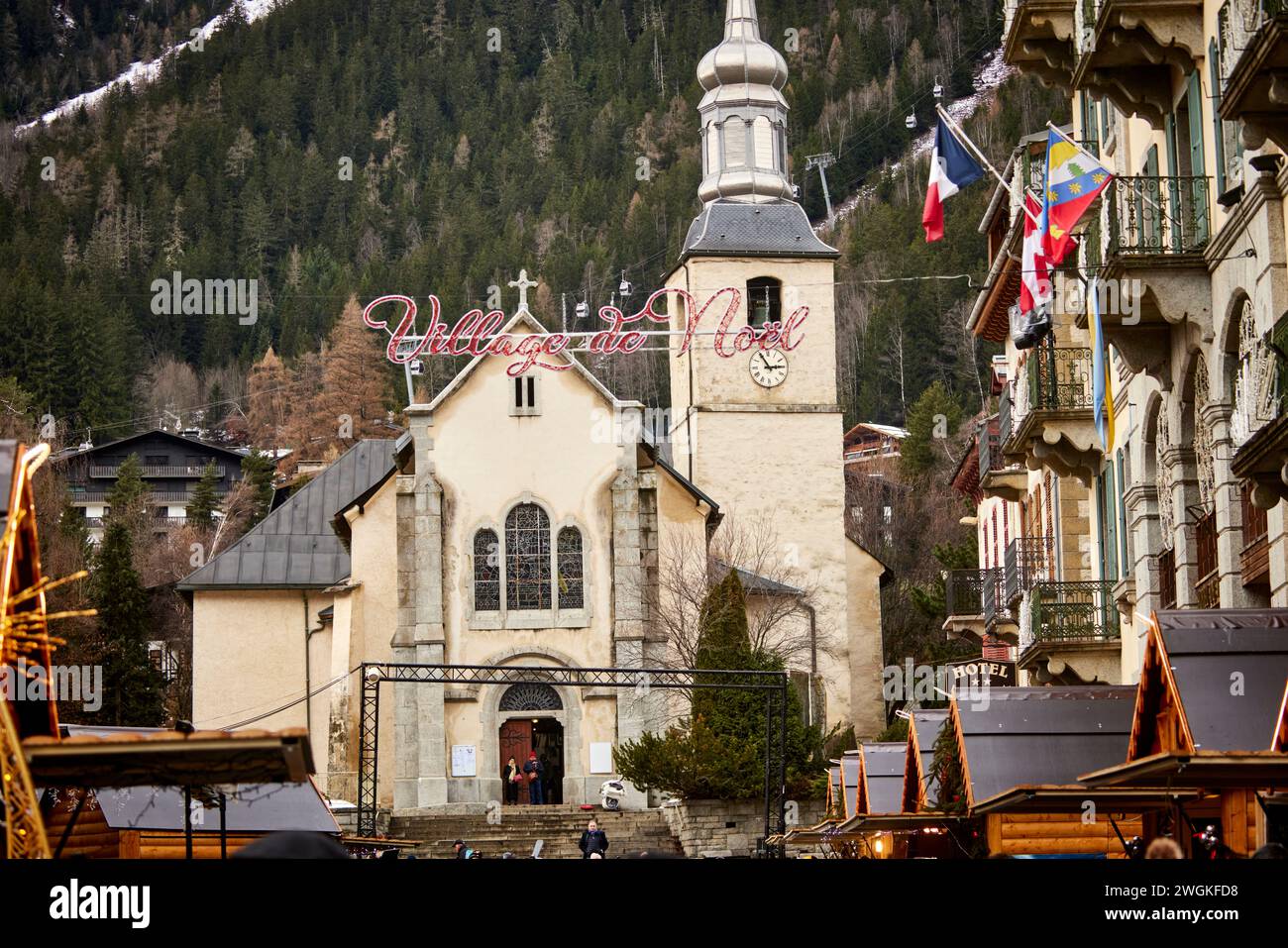 Chamonix Mont Blanc, Francia. Village de Neol chalet in legno, area del mercato di Natale incorniciata dalla chiesa di San Bernardo del Monte bianco di Paroisse Foto Stock